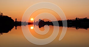 Sunset over the lake - still water reflection - industrial area landscape in town