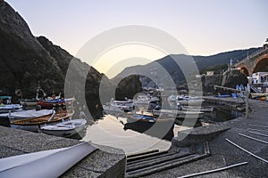 sunset over the Ligurian sea, cliffs, and boats on the waves in Framura, Italy. Marina at dusk