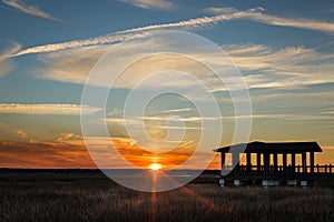 Sunset over marsh with covered pier