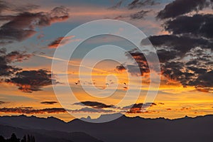 Sunset over the mountains. Dramatic sky at sunset with red, yellow and orange colors. Lausanne, Switzerland