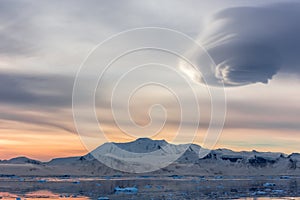 Sunset over the mountains with glaciers and drifting icebergs at