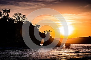 Sunset over the ocean behind a island. Crystal bay beach, Bali