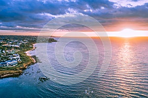 Sunset over ocean near coastline.