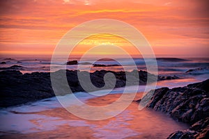 Sunset over ocean, rocks and waves