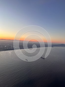 Sunset over the ocean with a ship sailing in the tranquil waters