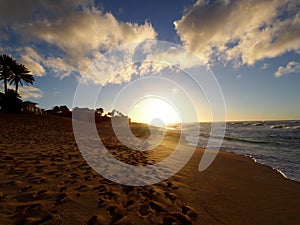 Sunset over the ocean with waves moving to shore