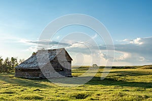 Sunset over old, abandoned barn in a prairie pasture at sunset in Saskatchewan, Canada