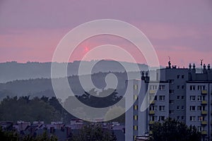 Sunset over the outskirts of the city among the mountains.