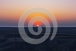 Sunset over plowed farm fields