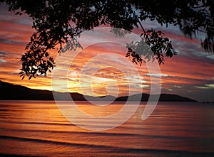 Sunset over the rippling water of a bay.