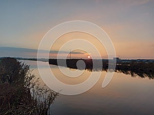 Sunset over the river Rotte in Zevenhuizen with windmills of the Molenviergang