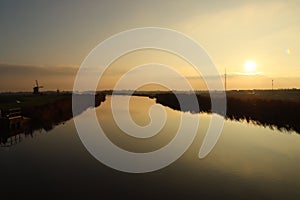 Sunset over the river Rotte in Zevenhuizen with windmills of the Molenviergang