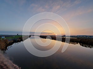 Sunset over the river Rotte in Zevenhuizen with windmills of the Molenviergang