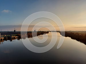 Sunset over the river Rotte in Zevenhuizen with windmills of the Molenviergang