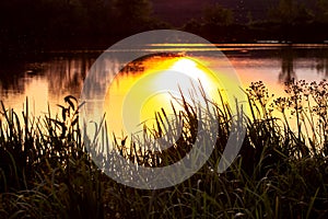 Sunset over the river. The sun and the picturesque sky in the evening are reflected in the river