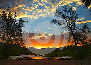 Sunset over a river with trees