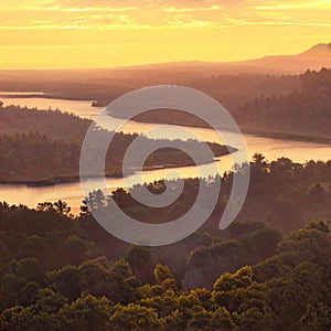 Sunset over river winding through a forest