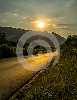Sunset over the road near the mountains