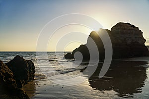 Sunset over the rock formations on a beach.