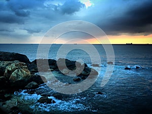 Sunset over the rocks in the Indian Ocean with the storm clouds near Galle, Sri Lanka, March 2019