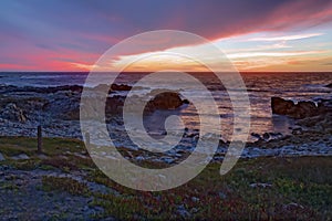 Sunset over rocks and sand at Asilomar State Beach in California photo