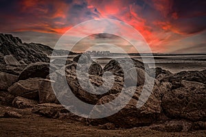 Sunset over rocks by the sea