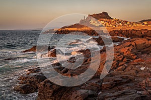 Sunset over rocky beach near Castelsardo, Sardinia, Italy