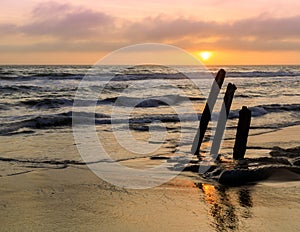 Sunset over ruined old pier pilings at Fort Funston Beach