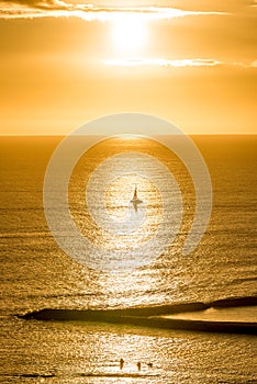 Sunset over a sailboat off Magic Island on Oahu, Hawaii