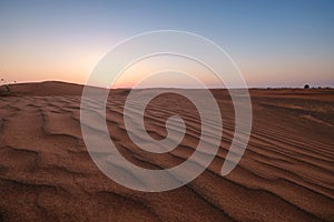 Sunset over the sand dunes in the desert