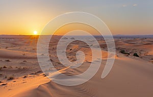 Sunset over the sand dunes in the desert. Arid landscape of the Sahara desert