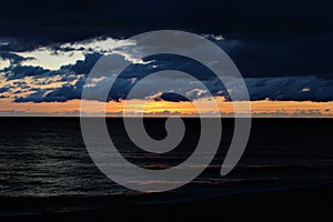 Sunset over the sea in Aberystwyth with atmospheric cloudy sky