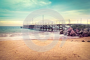 Sunset over the sea bridge in Ravda, Bulgaria. Slow motion effect. Old rusty pier against the sunset rays.