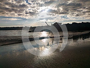 Sunset over the sea with a cloudy and dramatic sky.