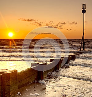 Sunset over the sea and concrete groynes.