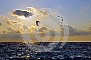 Sunset over the sea with kite surfers