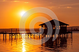 Sunset over the sea lake and old wooden pier, romantic travel destination, nature landscape