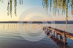 Sunset over the sea lake and old wooden pier, romantic travel destination, nature landscape