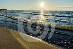 Sunset over the sea. Red and yellow sky in the rays of the sunset. Reflection of sunlight in the sea waves