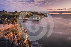 Sunset over sea shore rocks and mount Taranaki, New Zealand