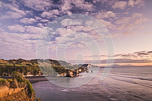 Sunset over sea shore rocks and mount Taranaki, New Zealand