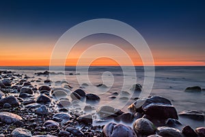 Sunset over the sea. Stone on the foreground.