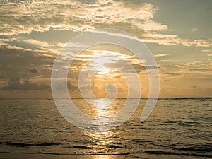 Sunset over sea. Sun light reflect with sea wave surface and flare. Summer time for vacation and holiday