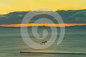 Sunset over seacoast with transport ship