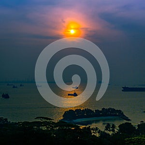 Sunset over the Singapore Strait with cargo boats and transportation ships and vessels importing and exporting goods across Asia
