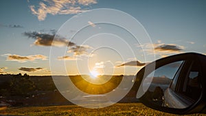 Sunset over small country town with car mirror