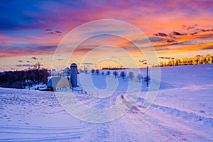 Sunset over a snow covered road and a farm in a rural area of York County, Pennsylvania