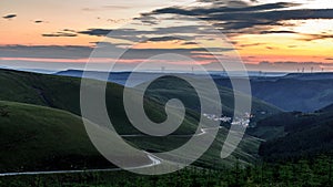 Sunset over the south Wales valleys from the Bwlch mountain. A road winds around the hillside to the village of Abergwynfi.