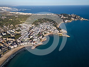 sunset over streets of Spanish touristic city Salou, Catalonia, aerial view of beach, sea and coast with palm trees