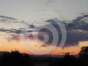 Sunset over the town, bright sky with pink, orange and purple clouds.